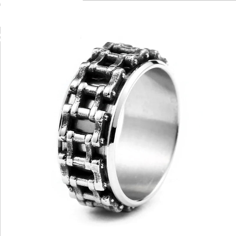 Metallic ring with chain-like design on a white background