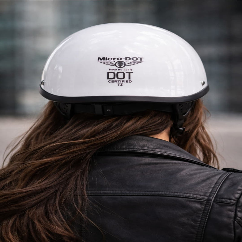 Person wearing a white helmet with Micro-DOT certification logo, blurred background